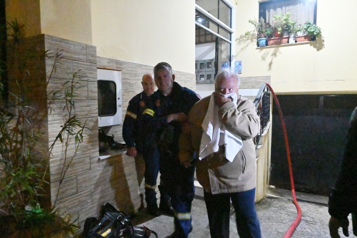 Ηλικιωμένος προσπαθεί να προστατεύσει το στόμα και τη μύτη του εν μέσω αποπνικτικής ατμόσφαιρας λόγω της φωτιάς