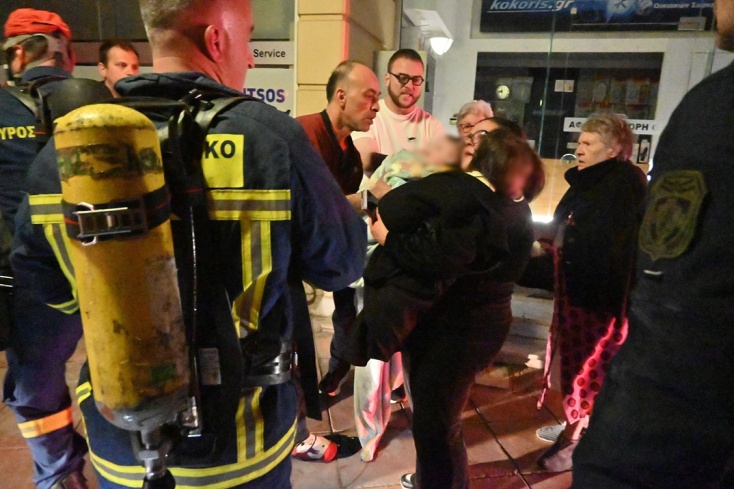 Ένα βρέφος ανάμεσα στους ενοίκους που βγήκαν από άλλα διαμερίσματα της πολυκατοικίας στο Άργος