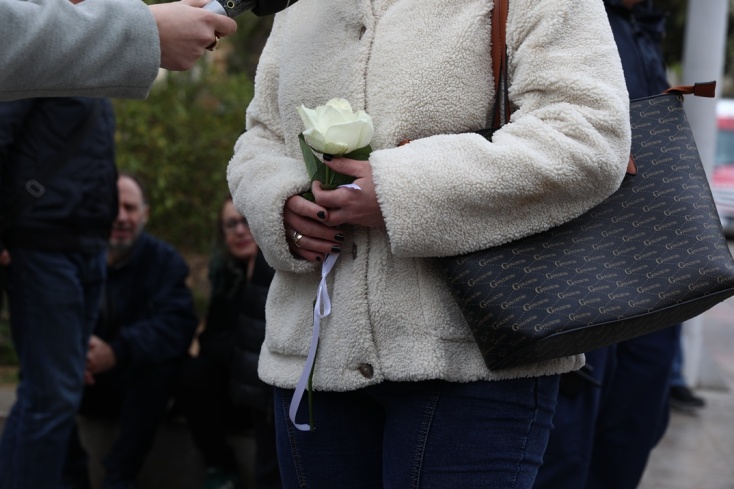 Γυναίκα κρατά ένα λευκό λουλούδι στο χέρι για να αποχαιρετήσει τη Μαρινέλλα