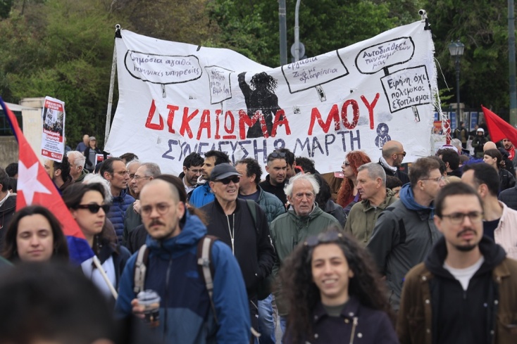 Πολίτες με πανό σε πορεία για την Εργατική Πρωτομαγιά στο κέντρο της Αθήνας