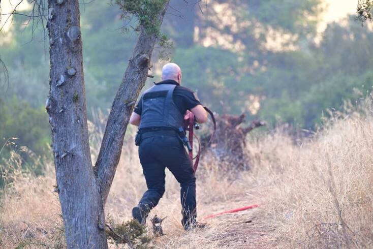 Κουβαλώντας τη μάνικα για τη φωτιά στο Χαϊδάρι, που καίει το Ποικίλο Όρος
