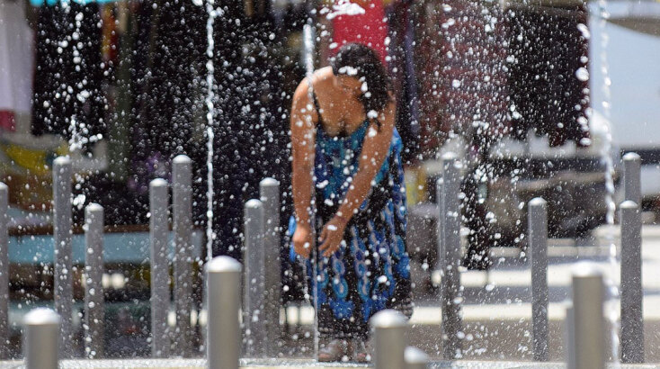 Γυναίκα δροσίζεται σε σιντριβάνι