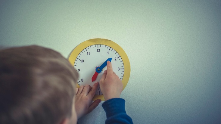 Παιδί παίζει με τους δείκτες ρολογιού