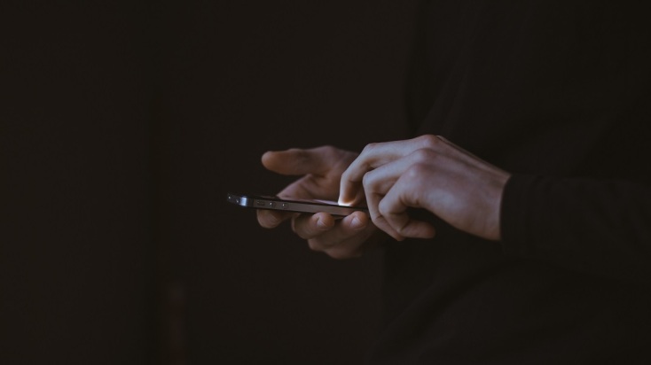 Χέρια πληκτρολογούν σε τηλέφωνο