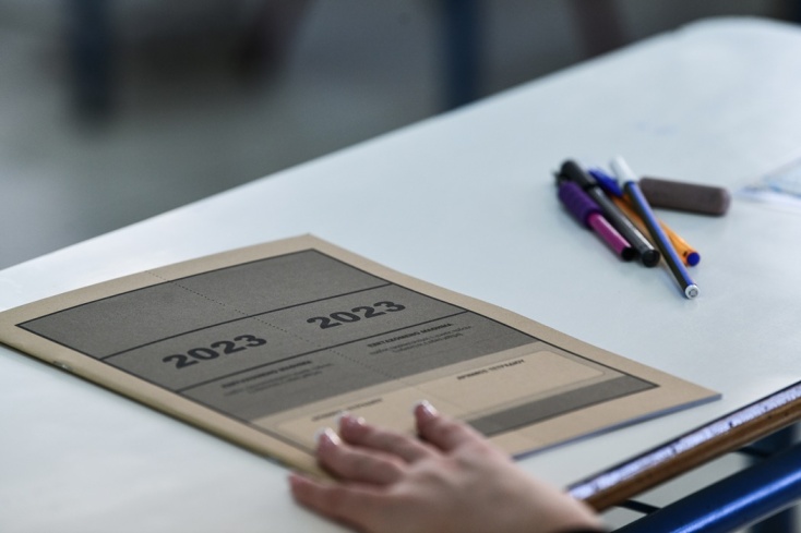 Τετράδιο εξετάσεων και παραταγμένα στιλό σε θρανίο για τις Πανελλήνιες 2023