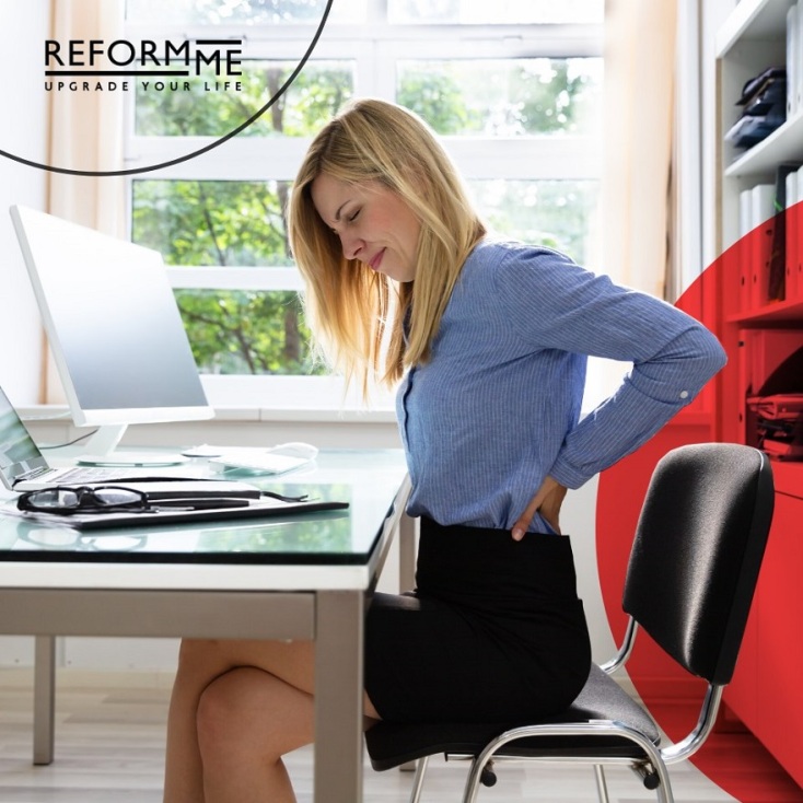 Γυναίκα καθισμένη σε καρέκλα-μπάλα Fit-Chair® μπροστά σε γραφείο