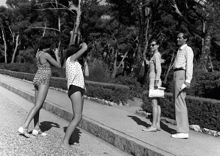 Δύο ενθουσιασμένα κορίτσια φωτογραφίζουν την Όντρεϊ Χέμπορν και τον σύζυγό της Mel Ferrer, που κάνουν διακοπές στο Cap d’Antibes, 1956