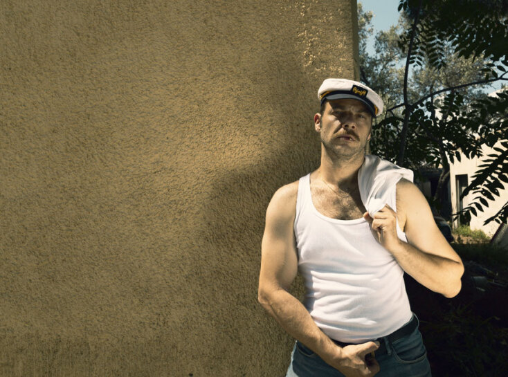 Άνδρας με λευκό φανελάκι και ναυτικό καπέλο