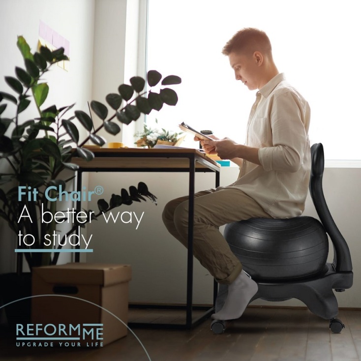 Άνδρας καθισμένος σε καρέκλα-μπάλα Fit-Chair® μπροστά σε γραφείο