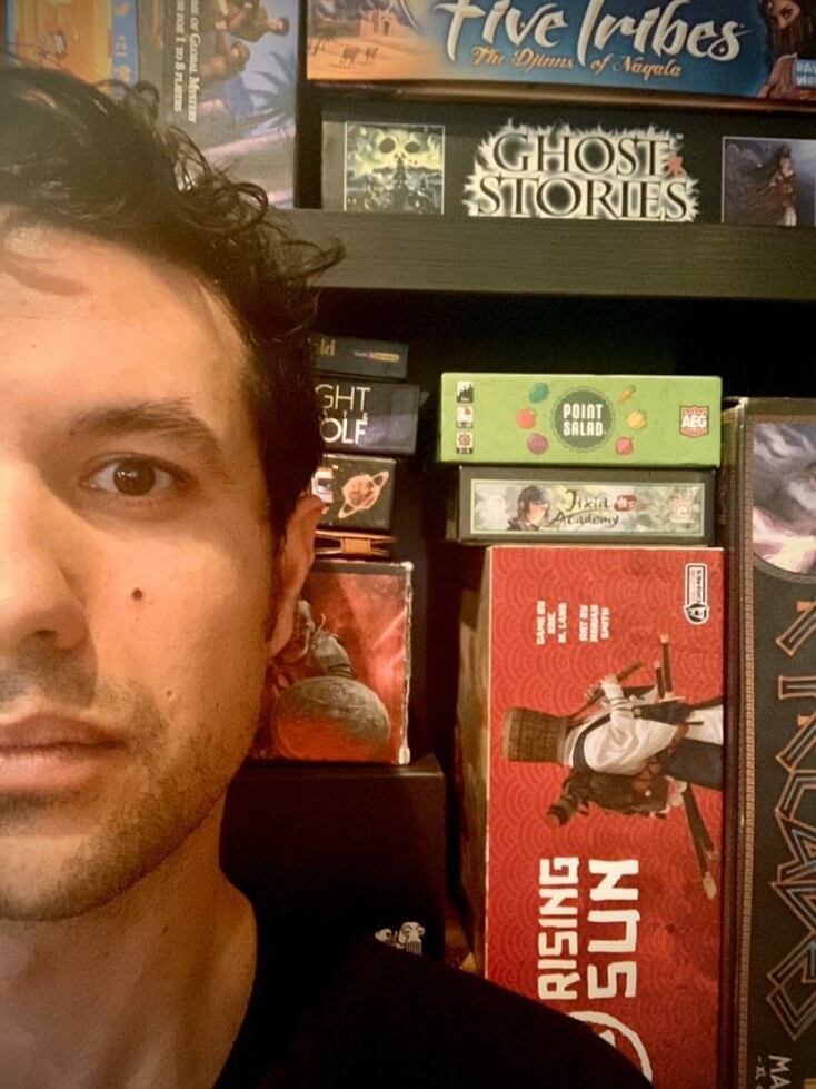 Ο Ορφέας Αυγουστίδης μπροστά από τα επιτραπέζια που μας προτείνει για όσο Μένουμε Σπίτι