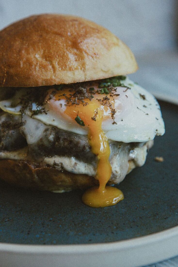Premium Burger: μοσχαρίσιος κιμάς, truffle mayo, taleggio, τηγανιτό αυγό μάτι, crispy bacon και φρέσκια τρούφα 
