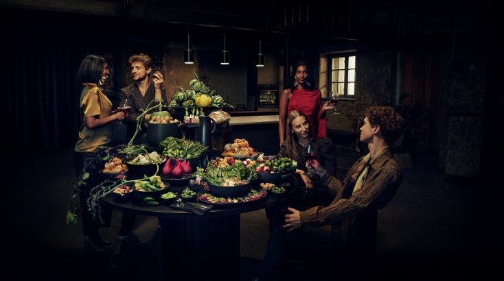 Άνθρωποι κάθονται γύρω από τραπέζι σε σπίτι