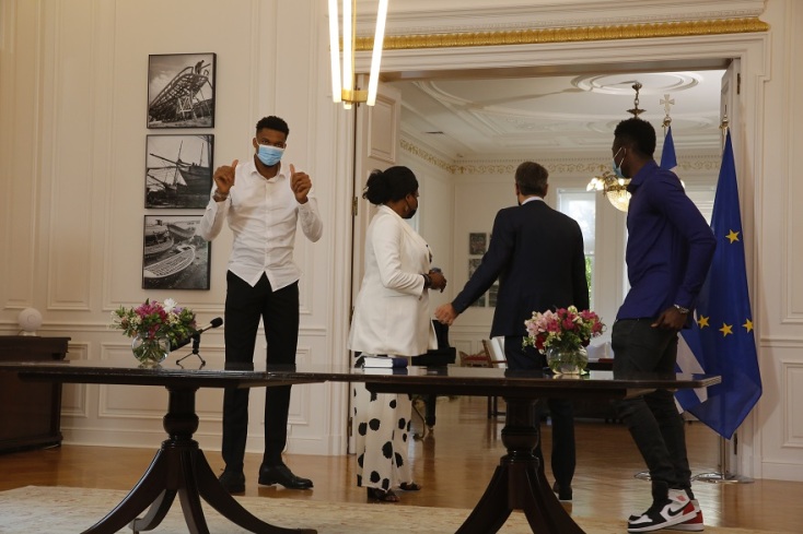 O Γιάννης Αντετοκούνμπο  κάνει χειρονομία επιβράβευσης μετά το τέλος της τελετής πολιτογράφησης της μητέρας του Βερόνικας και του αδερφού του Άλεξ Αντετοκούνμπο 