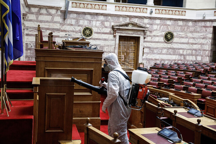 Υπάλληλος συνεργείου απολύμανσης για τον κορωνοϊό στην αίθουσα της Ολομέλειας στη Βουλή