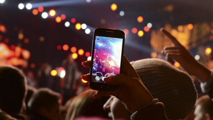 Άτομα σε συναυλία με κινητό τηλέφωνο υπερυψωμένο να τραβάει βίντεο
