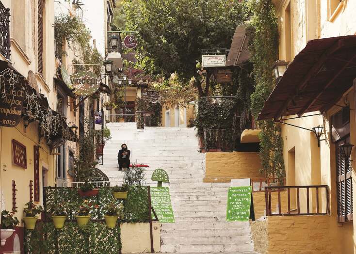 Γυναίκα με μάσκα που κάθεται σε σκαλιά στην περιοχή Αναφιώτικα στην Αθήνα κατά την περίοδο του lockdwon