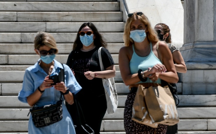 Κορωνοϊός: Γυναίκες φορούν τις μάσκες προστασίας και περπατούν στο κέντρο της Αθήνας