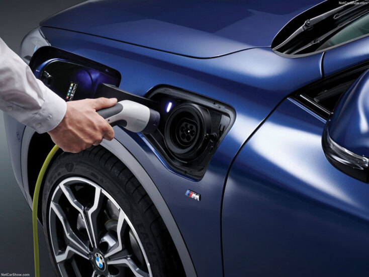 Ανδρικό χέρι συνδέει πρίζα σε ηλεκτρινκό αυτοκίνητο