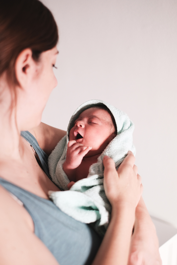 Γυναίκα που κρατά στην αγκαλιά της το νεογέννητο μωρό της