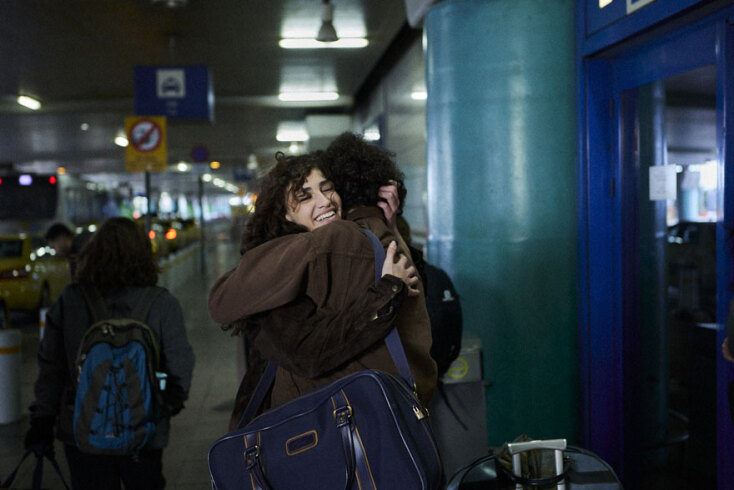 Δύο γυναίκες αγκαλιάζονται με φόντο το αεροδρόμιο