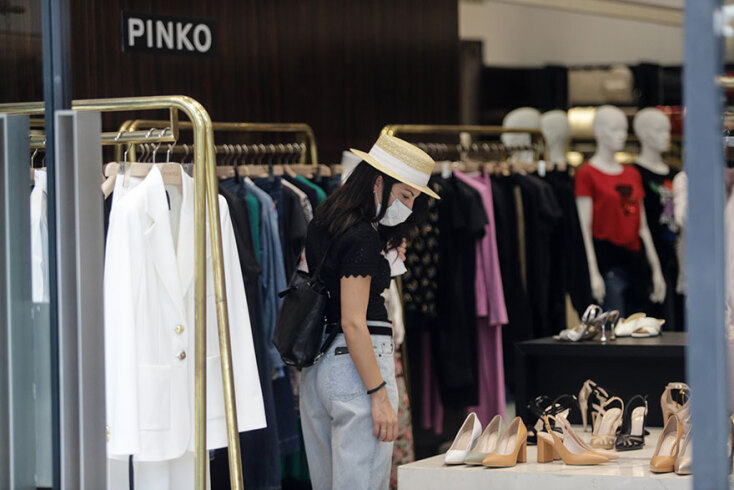 Εμπορικό κέντρο: Κοπέλα με μάσκα για τον κορωνοϊό μπροστά από κατάστημα