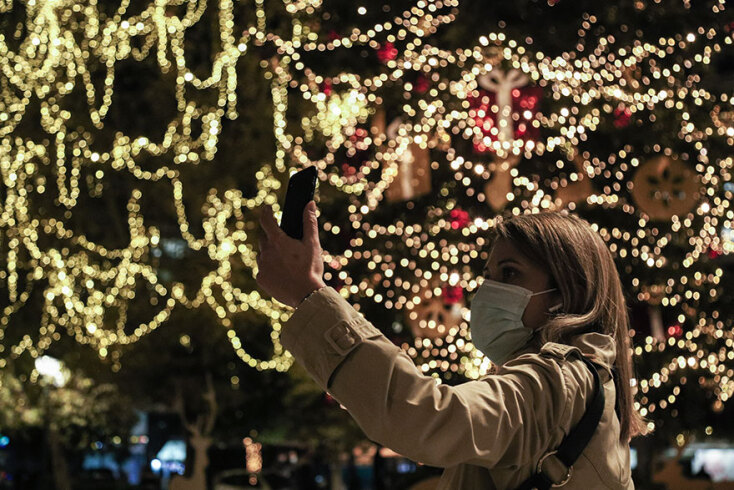 Γυναίκα με μάσκα βγάζει selfie στο χριστουγεννιάτικο δέντρο στο Σύνταγμα
