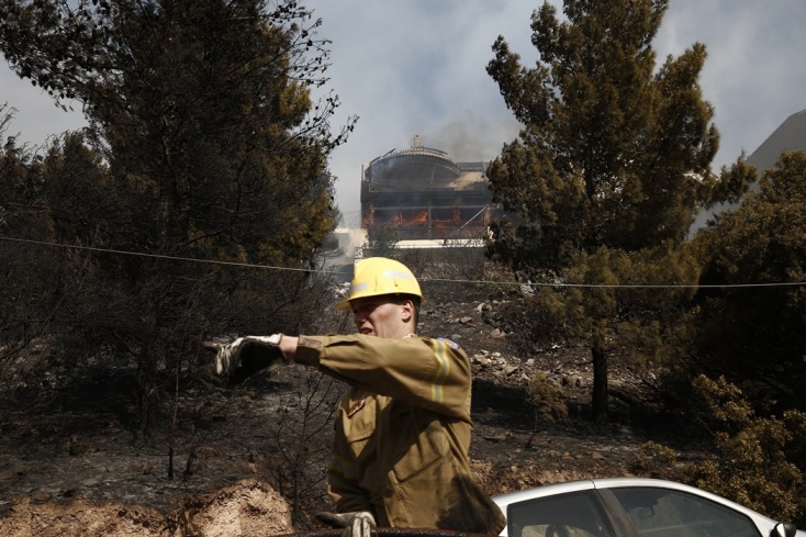 Φωτιά τώρα στη Βούλα: Πυροσβέστης μπροστά από κτίριο που καίγεται