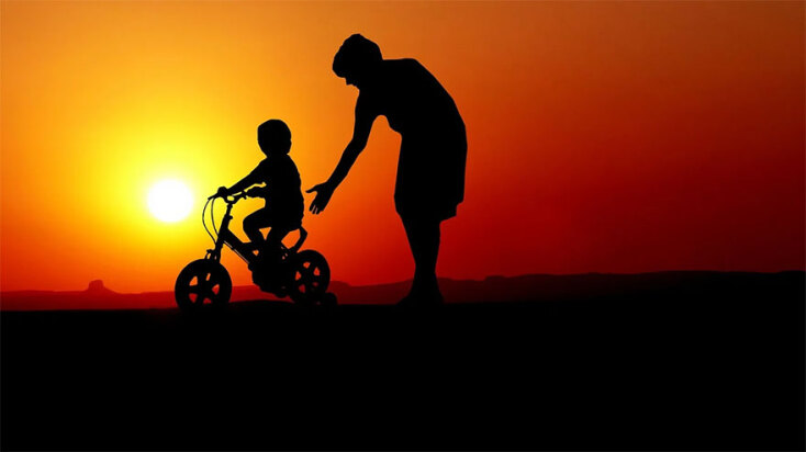 Μητέρα βοηθά το παιδί της να κάνει ποδήλατο - Η γιορτή της μητέρας είναι μια ευκαιρία για μια αγκαλιά στη μαμά που φροντίζει και αγαπά