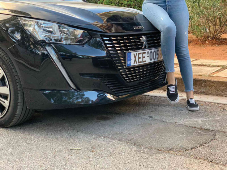 Κοπέλα καθισμένη σε καπό αυτοκινήτου Peugeot