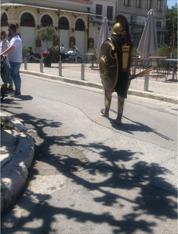 Άνδρας ντυμένος σπαρτιάτης πολεμιστής περπατάει στο δρόμο