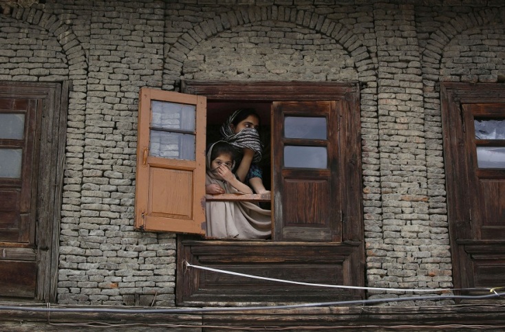 Δύο μικρά κορίτσια παρατηρούν τον δρόμο σε πόλη της Ινδίας