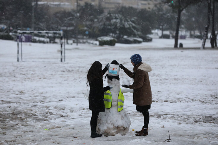 Χιόνια στην Ιερουσαλήμ: Ένα ζευγάρι φτιάχνει χιονάνθρωπο, βάζοντάς του και μια μάσκα για τον κορωνοϊό