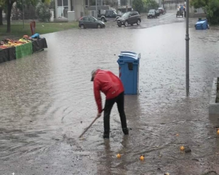 Κακοκαιρία Genesis: Πολίτης στη Λάρισα με σκούπες ανά χείρας προσπαθεί να ανοίξει φρεάτιο