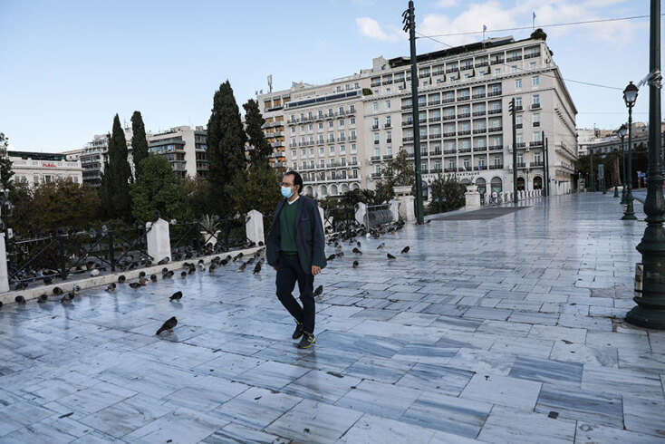 Lockdown: Πολίτης με μάσκα περπατά στην πλατεία Συντάγματος, την πρώτη ημέρα εφαρμογής του νέου απαγορευτικού για τον κορωνοϊό
