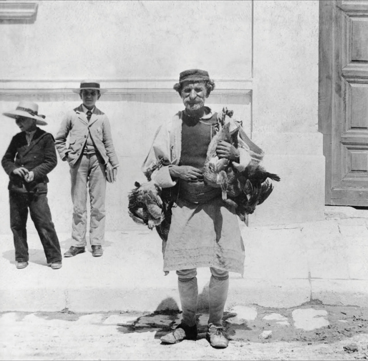 Δύο μαθητές, αστοί, με τα βιβλία τους, ντυμένοι με ευρωπαϊκά ρούχα, και ένας ηλικιωμένος πλανόδιος πωλητής,  που πουλάει πάπιες, ντυμένος με την παραδοσιακή φορεσιά του.