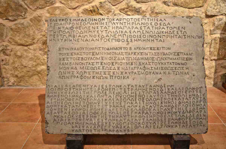 Μαρμάρινη πλάκα που αφορά τους κανόνες εμπορίας και καλλιέργειας του κρασιού σαν τους σημερινούς νόμους για τα κρασιά Π.Ο.Π. και Π.Γ.Ε.