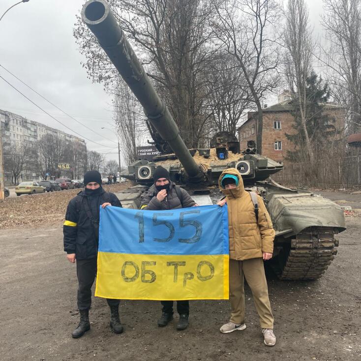 Ο Illia με άλλα δύο παιδιά από την ομάδα αστικής περιπολίας του Σούμι μπροστά από ένα άρμα μάχης