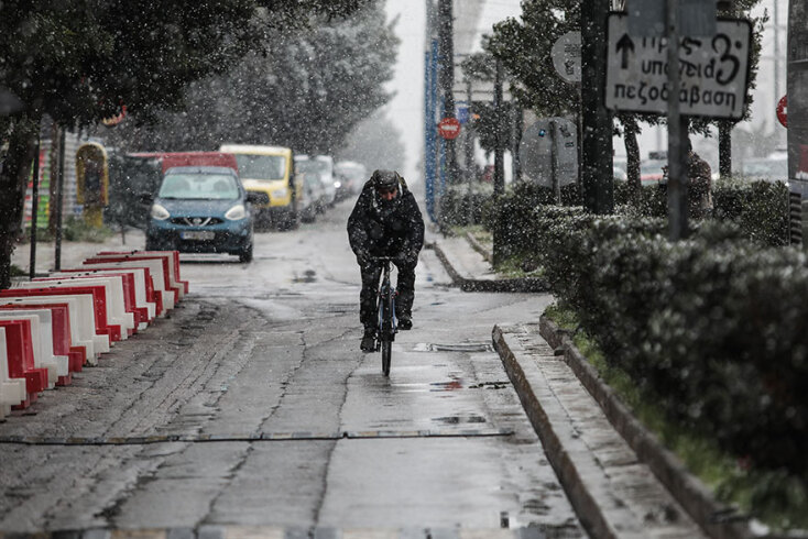 Ποδηλάτης στον χιονισμένο παράδρομο της Λεωφόρου Συγγρού