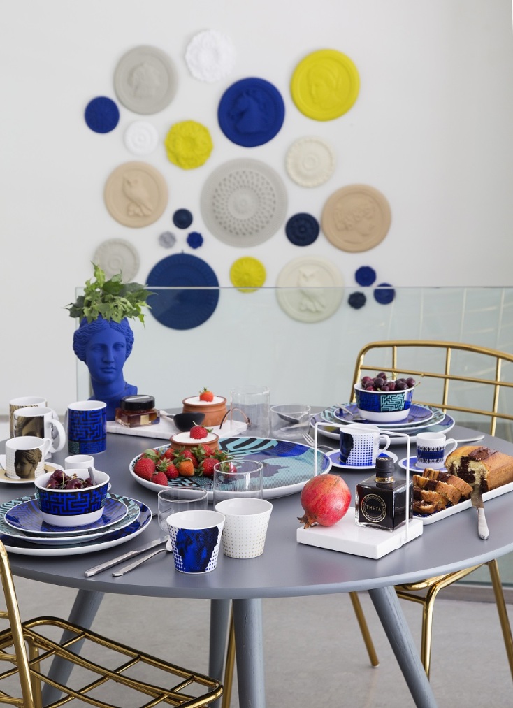 Στρογγυλό τραπέζι κουζίνας διακοσμημένο με πιάτα, ποτήρια και διακοσμητικά