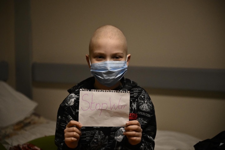 Παιδί κρατά φύλλο χαρτιού με αντιπολεμικό μήνυμα για τον πόλεμο στην Ουκρανία