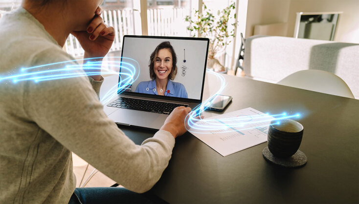 Άνδρας καθισμένος σε γραφείο με ανοιχτό laptop μπροστά του