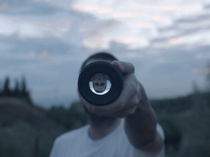 άνδρας πίσω από φακό κάμερας 