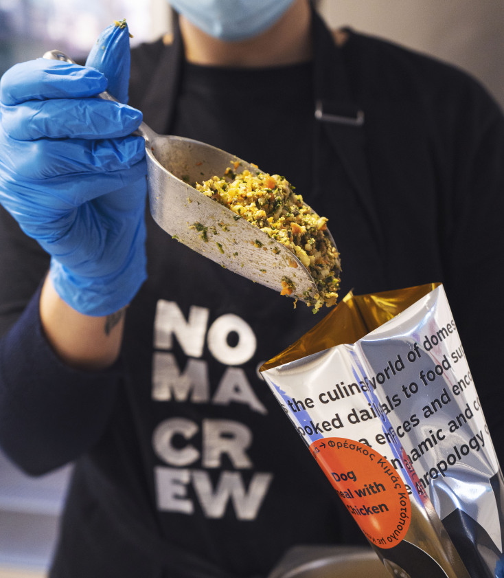 άνθρωπος βάζει τροφή σκύλου σε σακούλι