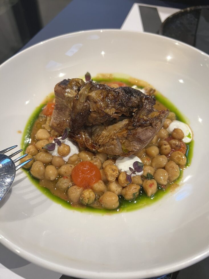 Αρνί με τη ρεβιθάδα, με αρωματικό γιαούρτι με μπαχαρικά, τζελ πιπεριάς Φλωρίνης και λάδι κόλιανδρου