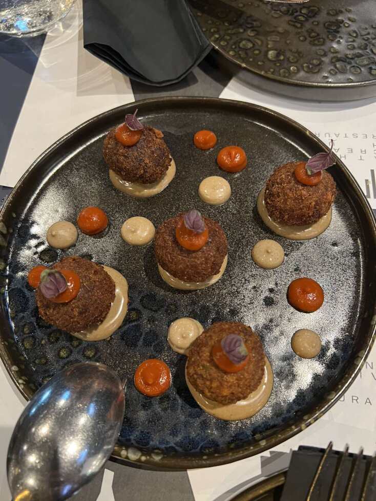 Κροκέτες μοσχαρίσιου σιδηρόδρομου που έχουν μαγειρευτεί slow cooked και συνοδεύονται με αγιολί μαύρου σκόρδου και κέτσαπ από πιπεριά Φλωρίνης.