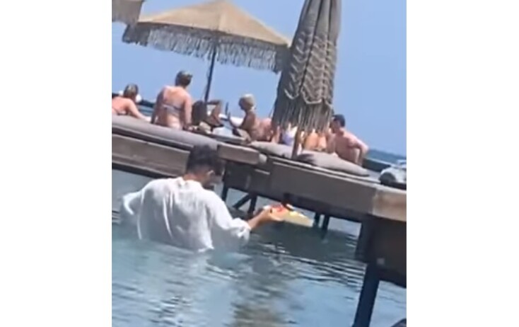 Σερβιτόρος σχεδόν κολυμπά για να παραδώσει παραγγελία στη Ρόδο