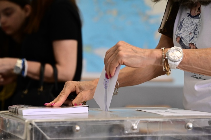 Χέρι γυναίκας ρίχνει ψηφοδέλτιο σε κάλπη