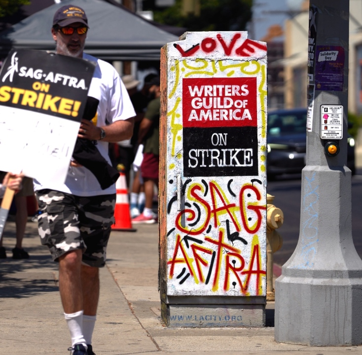 A protestor holds a poster reading 'AI Can't Overact as Well as I Do' as SAG-AFTRA members and supporters demonstrate in front of Netflix headquarters on a post-apocalyptic theme in Los Angeles, California, 08 November 2023. The Screen Actors Guild-American Federation of Television and Radio Artists (SAG-AFTRA) has been on strike since 14 July 2023, it is the longest strike in SAG-AFTRA history. EPA/ETIENNE LAURENT