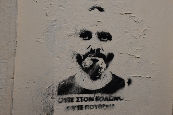 Ο Ηλίας Μίχος σε τοίχο με σύνθημα