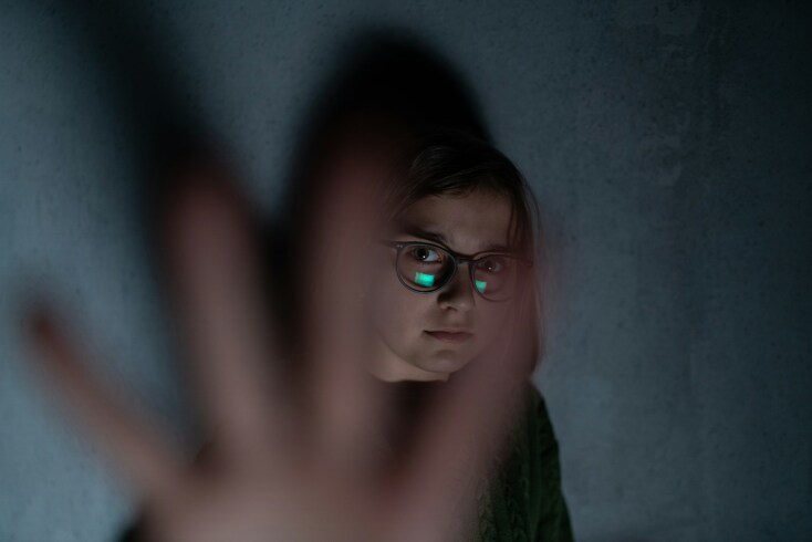 Κορίτσι με γυαλιά προτάσσει το χέρι του για να αποφύγει επίθεση - Εικόνα που παραπέμπει σε βία, σχολικό εκφοβισμό και bullying